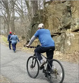  ?? ?? A biker passes along the Chester Creek Trail in Middletown Tuesday afternoon. Built on the Civil War-era Chester Creek Branch line of the Pennsylvan­ia Railroad, the trail is 2.8 miles long.