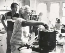  ?? David Valdez / Getty Images ?? Neil Bush watches his mother, Barbara Bush, cook in her bustling kitchen in 1990.