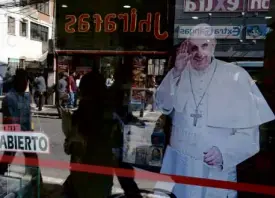  ?? REUTERS ?? THE FRANCIS EFFECT IN BOLIVIA An image of Pope Francis is displayed in a shop in La Paz, the capital of Bolivia, where the Argentine Pope hopes to chew coca leaves.