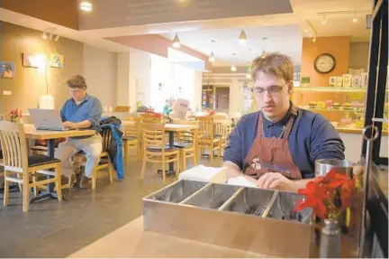  ?? KARL MERTON FERRON/BALTIMORE SUN ?? Sam Myers, right, organizes items at Sam’s Canterbury Cafe while his father, Michael, works in the background.