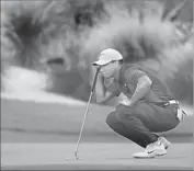  ?? Mike Ehrmann Getty Images ?? TIGER WOODS lines up a putt during a third round in which he shot a 75 and fell 10 shots off the lead.