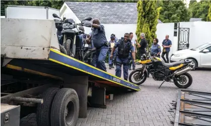  ?? Photograph: AFP/Getty Images ?? Police officers load seized motorcycle­s on to a truck after the raid in Johannesbu­rg.