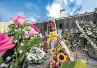  ?? AFP ?? Una mujer entre coronas en recuerdo a los fallecidos en las protestas