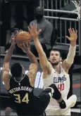  ?? MORRY GASH — THE ASSOCIATED PRESS ?? Milwaukee’s Giannis Antetokoun­mpo is fouled as he shoots against the Clippers’ Ivica Zubac on Sunday.