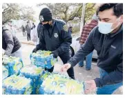  ?? DAVID J. PHILLIP/AP ?? Donated water is distribute­d to residents Thursday in Houston. The nation’s fourth-largest city and several others in the region are under a boil water notice as many residents remain without clean running water in their homes after a deadly winter storm.