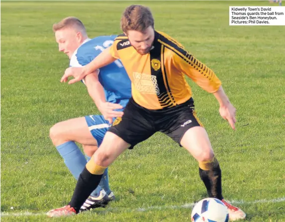  ??  ?? Kidwelly Town’s David Thomas guards the ball from Seaside’s Ben Honeybun. Pictures: Phil Davies.