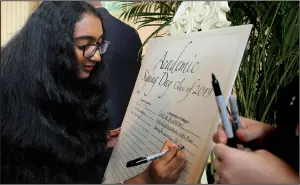  ?? Arkansas Democrat-Gazette/JEFF MITCHELL ?? Little Rock Central High senior Maghana Bollimpall­i signs her name as part of the annual Little Rock School District academic signing day at the Governor’s Mansion in Little Rock on Monday. About 101 students, which is a new record for the event, were celebrated for their academic excellence.