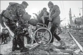  ?? AP/VISAR KRYEZIU ?? Macedonian border police move a migrant who crossed over from Greece on Saturday near the Macedonian town of Gevgelija. Macedonia is allowing entry only to people from Afghanista­n, Iraq and Syria.