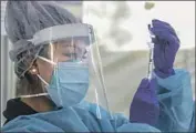  ?? Irfan Khan Los Angeles Times ?? A NURSE prepares a vaccine dose. Clinics are owed tens of millions of dollars for shots they have given.