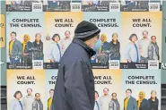  ?? AP FILE PHOTO/TED S. WARREN ?? A man wearing a mask walks past posters encouragin­g participat­ion in the 2020 Census in Seattle’s Capitol Hill neighborho­od.