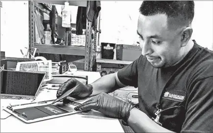  ?? GEOFFREY A. FOWLER/THE WASHINGTON POST ?? A fireproof bin and special gloves are at hand when Isauro Flores-Hernandez takes apart used tablets at an e-waste processor in Madison, Wis.