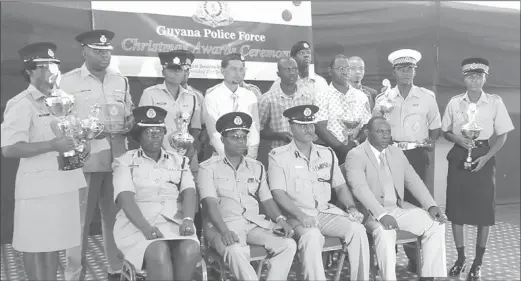  ??  ?? Those awarded during the GPF’s Christmas awards ceremony, along with the Acting Commission­er of Police David Ramnarine (seated second from right) and Commander Clifton Hicken, (third from right)