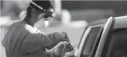  ??  ?? A person is tested for COVID-19 at a drive through testing site hosted by the HeroZona Foundation in the South Mountain Community College parking lot in Phoenix on July 9.