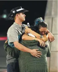  ??  ?? People comforting each other outside the Thomas & Mack Center.