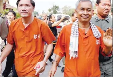  ?? PHA LINA ?? Adhoc officials Ny Sokha (left) and Yi Soksan are escorted last month into the Supreme Court, where their bail appeal was denied in Phnom Penh.