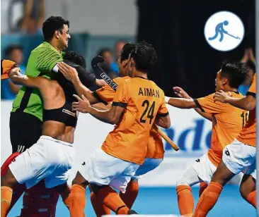  ??  ?? You’re the man: Malaysian players rushing to hug goalkeeper S. Kumar after the latter made a crucial save in the shootout against India in the semi-finals yesterday. — AFP