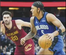  ?? Associated Press ?? Orlando Magic forward Paolo Banchero (5) drives past Cleveland Cavaliers forward Georges Niang (20) during the second half on Monday in Orlando, Fla.