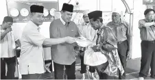  ??  ?? SAMSUDIN menyampaik­an sumbangan daripada Yadim Sabah berupa barangan keperluan asas di Kg Asam, Zon Kepulauan DUN Sekong.