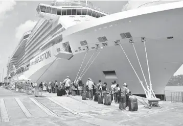  ?? ORVIL SAMUEL/AP ?? To the rescue: British, Canadian and U.S. nationals line up alongside the Royal Caribbean cruise ship Reflection to be evacuated free of charge on Friday from Kingstown on the eastern Caribbean island of St. Vincent. La Soufriere volcano shot out another explosive burst of gas and ash Friday morning as the cruise ship arrived.