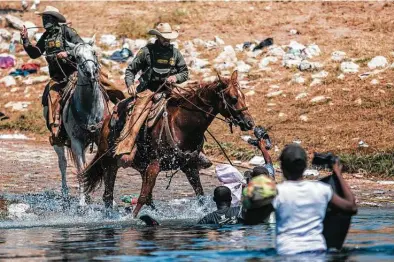  ?? Felix Marquez / Associated Press ?? Mounted officers with Customs and Border Protection attempt to gather migrants as they cross the Rio Grande from Ciudad Acuña into Del Rio on Sunday. Thousands of Haitian migrants have been arriving in the Texas border town.