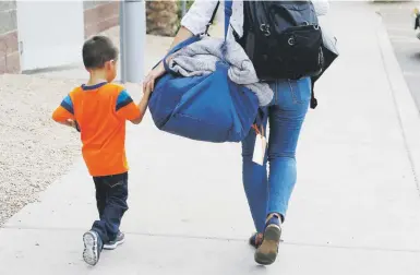  ?? ap photo/ross d. franklin ?? Un niño hondureño de 3 años es llevado por una empleada de una organizaci­ón sin fines de lucro a reunirse con su padre en la ciudad de Phoenix.