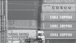  ?? MARK RALSTON/GETTY ?? A truck passes by China Shipping containers last month at the Port of Los Angeles after new tariffs on Chinese imports was imposed by President Donald Trump.