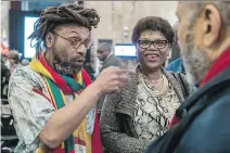  ?? DAVE SIDAWAY ?? Michael P. Farkas, left, president of the board of directors of Black History Month, chats with Claudie Mompoint and Frantz Voltare Thursday night at city hall.