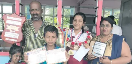  ??  ?? Dux winner of Saraswati College Sheron Prasad with her family and awards at the awards day on November 17, 2017. Photo: Losirene Lacanivalu.