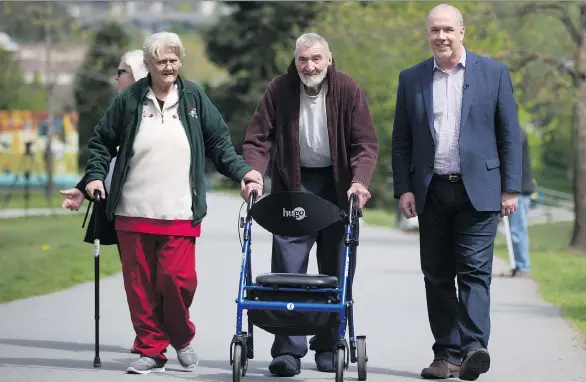  ?? DARRYL DYCK/THE CANADIAN PRESS ?? NDP Leader John Horgan, right, walks with Ruth and John La-Ballaster after driving them to a polling station to vote in the election in Coquitlam, Tuesday.