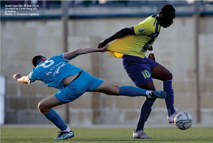  ?? ?? Ayad Liam Blie Bi Bah (R) is checked by Clyde Borg (R) of Zejtun.
Photos © Domenic Aquilina