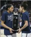  ?? JESSICA HILL — ASSOCIATED PRESS ?? Connecticu­t’s Gabby Williams and Kia Nurse, right, kiss the American Athletic Conference championsh­ip trophy after beating South Florida Tuesday in Uncasville, Conn.