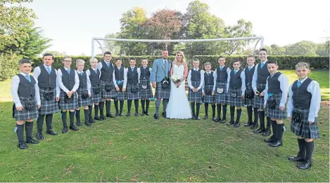  ?? Picture: Dougie Nicolson. ?? Relationsh­ip goals: Callum Kay and Danielle Millar, coaches at Fair City FC U13s, after their wedding at the Murrayshal­l Country House Hotel today, with the boys from the team cheering them on.