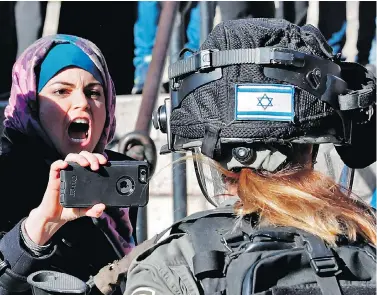  ?? THOMAS COEX/AFP/GETTY IMAGES ?? Palestinia­ns scuffle with Israeli forces at Damascus Gate in Jerusalem’s Old City on Friday as part of a “day of rage” over U.S. President Donald Trump’s decision to recognize Jerusalem as Israel’s capital earlier in the week.