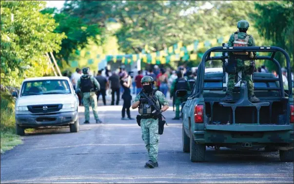  ?? (AP/Eduardo Verdugo) ?? Soldiers patrol Oct. 28 during celebratio­ns marking the feast day of Saint Jude in the hamlet Plaza Vieja in the Michoacan state of Mexico.