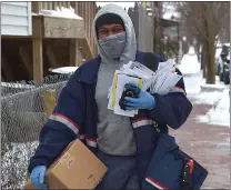  ?? PETE BANNAN — MEDIANEWS GROUP ?? West Chester mail carrier Wayne Irons has his hands full as he goes about his rounds Monday on South Matlack Street. Most sidewalks were cleared of snow, but slippery spots made for tricky walking.
