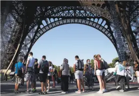  ?? Thibault Camus / Associated Press ?? Visitors line up to visit the Eiffel Tower in Paris after the pandemic led to the landmark structure’s longest closure since World War II — 104 days.