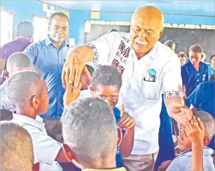  ?? Picture: JOVESA NAISUA ?? President Jioji Konrote is embraced by students of Bua District School in the Northern Division yesterday.