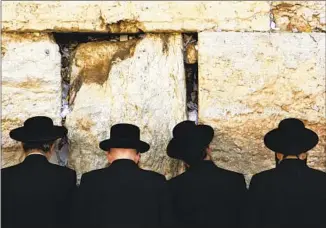  ?? MEN PRAY Kevin Frayer Associated Press ?? at Jerusalem’s Western Wall at the start of the Jewish holiday of Yom Kippur, a day of atonement, repentance, ref lection and prayer.