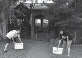  ?? PHOTOGRAPH­S COURTESY OF LODI HIGH SCHOOL ?? Mr. Atwater an Ms. Heinrich place signs on a lawn to recognize Lodi High School students getting fives on AP tests.