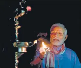  ?? ANI ?? Prime Minister Narendra Modi lights a lamp as a gesture of unity in the fight against Covid-19, at his residence in New Delhi on Sunday night.
