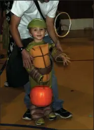  ?? Fort Morgan Times file photo ?? A little Ninja Turtle tosses a ring to see if lands around a soda pop or a water in a game at a previous Fall Fun Fest at Morgan Church of the Nazarene. This year’s event with games, prizes, candy, food and a Bible walk happens from 5:30 to 7:30 p.m. Sunday, Oct. 31.