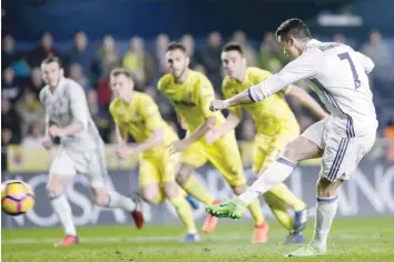  ?? — AFP ?? Real Madrid’s Cristiano Ronaldo (right) shoots to score a goal during the Spanish league match against Villarreal CF at El Madrigal stadium in Vila-real on Sunday.