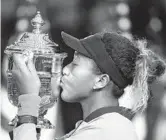  ?? JULIO CORTEZ/AP ?? Boca Raton resident Naomi Osaka kisses the trophy after defeating Serena Williams in last year’s women’s final of the U.S. Open in New York. Osaka is ranked No. 1 heading into the U.S. Open, where she will attempt to defend a Grand Slam title for the first time.