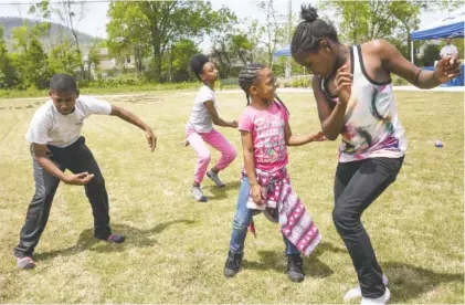  ?? STAFF PHOTO BY DOUG STRICKLAND ?? Jaleel Choice, Sa’Miyah Pickett, De’Angel Howard and Tyreanna King dance at a community festival at Southside Community Park following the Fagan Street cleanup effort. Organizers intend for the event to become an annual tradition for giving back to the...