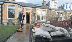  ??  ?? AFTERMATH: Residents of Peebles begin the clean-up after the River Tweed flooded the town.