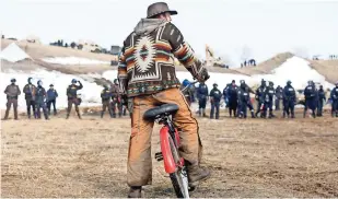  ??  ?? Un hombre observa el avance de las fuerzas de seguridad en el campamento contra Dakota Access