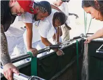  ?? ?? Family members place dirt on Andre’s casket during burial services Friday at First Memorial Park Cemetery.