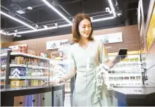  ?? Courtesy of Shinsegae I&C ?? A model enters the cashierles­s, automated emart24 store located at Shinsegae I&C’s new data center in Gimpo, Gyeonggi Province.