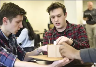  ?? LAUREN A. LITTLE — MEDIANEWS GROUP ?? Gov. Mifflin seniors Beny Iordanescu, left, and Tyler Dohn work on their earthquake-proof structure during the Project in a Box portion of the Berks County Intermedia­te Unite Governor’s STEM Competitio­n on Thursday.