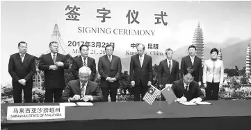  ??  ?? Mayor of Kuching City North Datuk Abang Abdul Wahab Abang Julai (seated left) signing the MoU with Tian Jiangquan, vice-governor of Dali Prefecture (seated right).